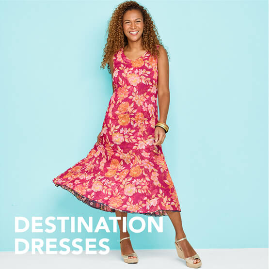 A female model, smiling, conducting a twirl in her floral pattern summer dress.